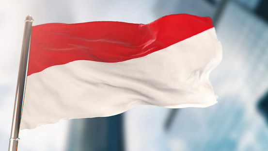 National Flag of Indonesia Against Defocused City Buildings